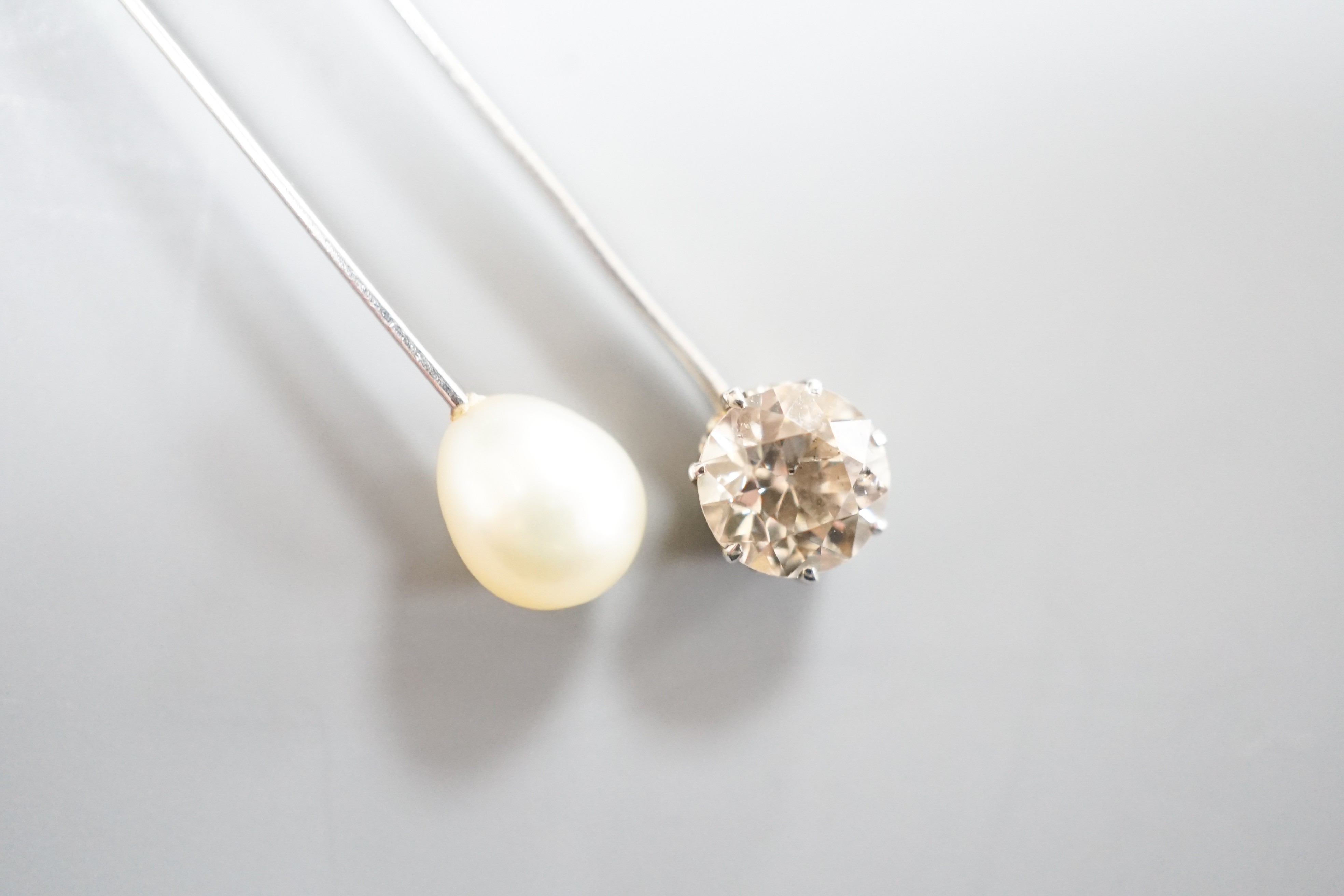 A 1940's white metal (probably platinum), three stone diamond and single stone teardrop shaped pearl set double drop pendant necklace, pendant 39mm, chain 41cm, gross weight 5.9 grams.